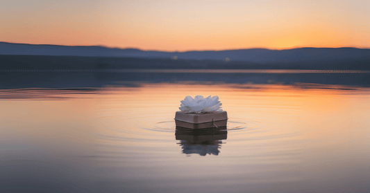 Biodegradable urn with white paper flower floating on calm ocean water during a spring memorial ceremony