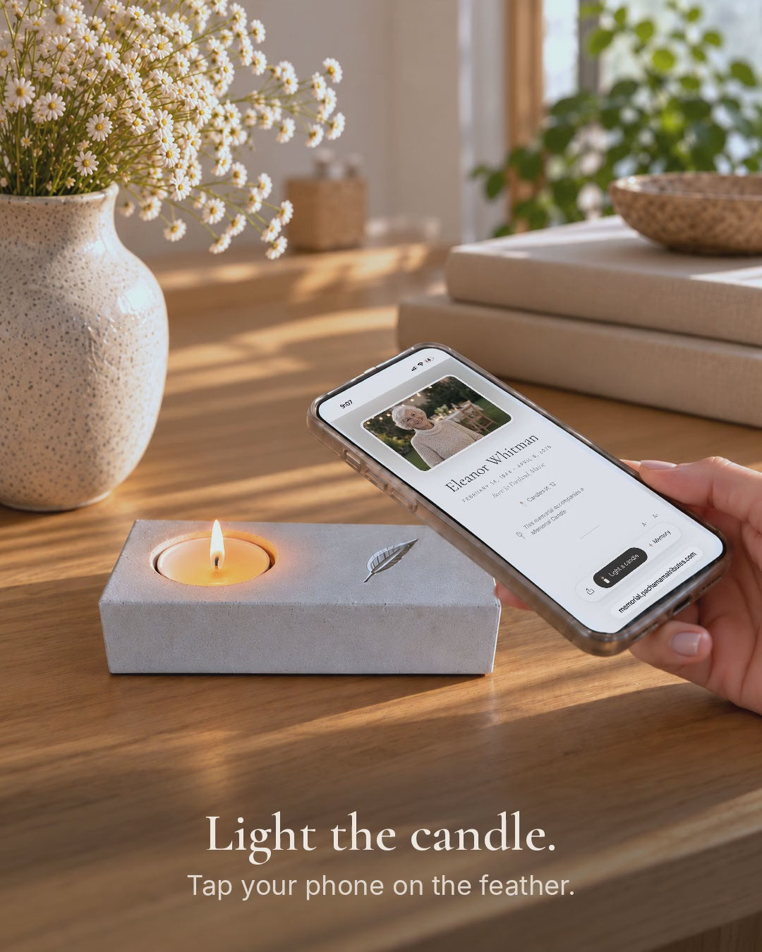 Video: a tea light is lit in the handmade concrete memorial candle holder, a phone rests on the engraved feather and the online memorial opens.